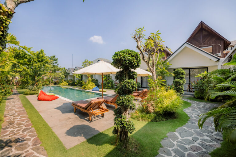 Pool and garden with peaked-roof bungalows at Sari Uma Canggu