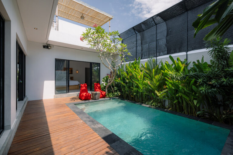 Private pool with red loungers and tropical plants at Arda Villa