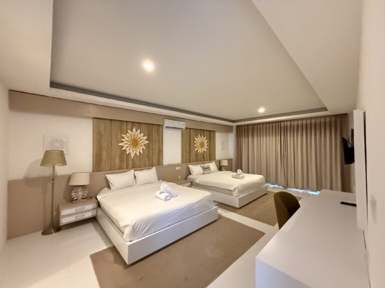 Bedroom with beds and sunburst mirror at Panoramic Villa