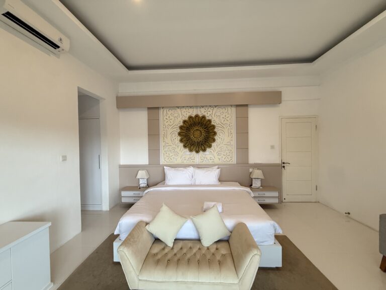 Bedroom with king-size bed and round wall decor at Panoramic Villa