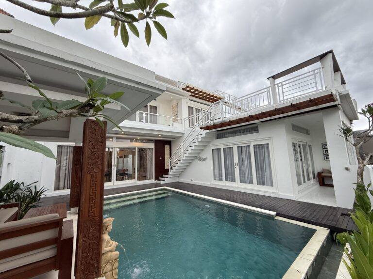 Swimming pool with lounge chairs and palm tree at Panoramic Villa
