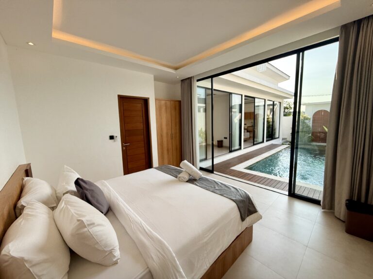 Bedroom with sliding glass doors open to the pool deck
