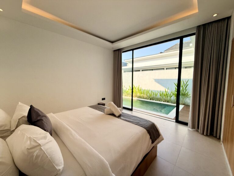 Bedroom with king-size bed facing glass doors to the pool