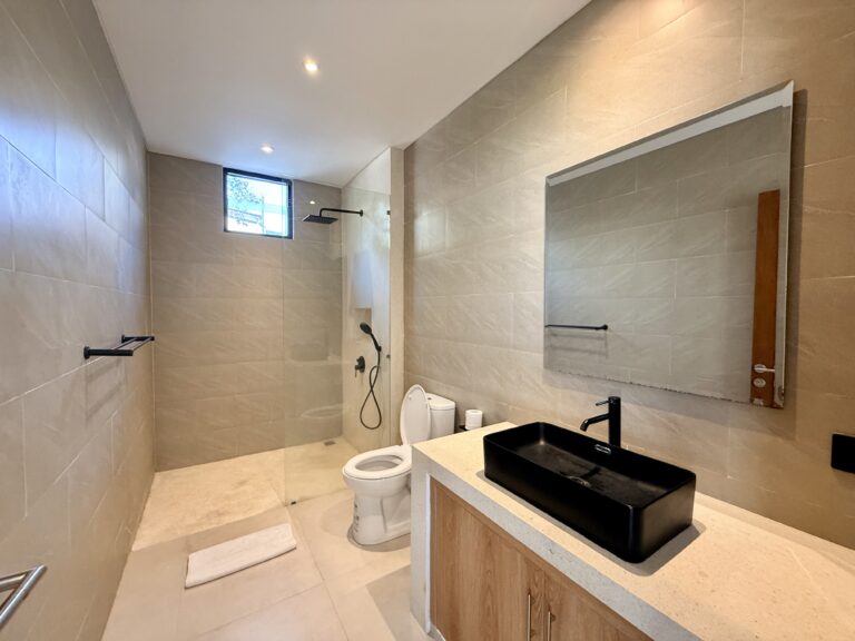 Bathroom with black stone basin, large mirror and rain shower