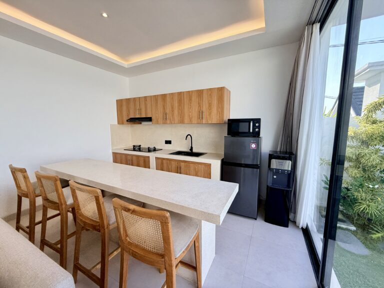 Kitchen bar with rattan stools, microwave, fridge and water dispenser