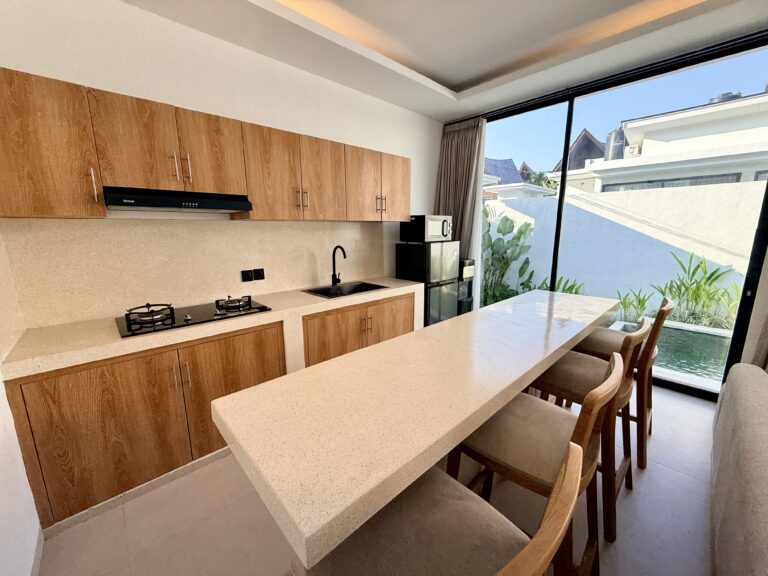 Kitchen with timber cabinets, gas hob, sink and breakfast bar