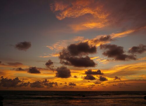 Dramatic orange sunset sky over the waves at Echo Beach, Canggu