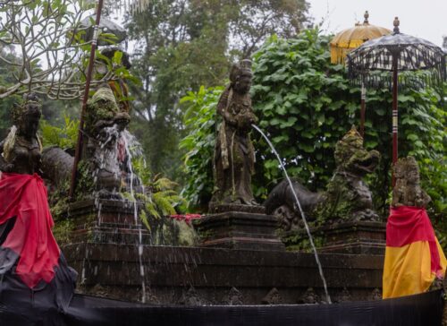 Stone deity statues pouring holy spring water at Pura Luhur Tamba Waras