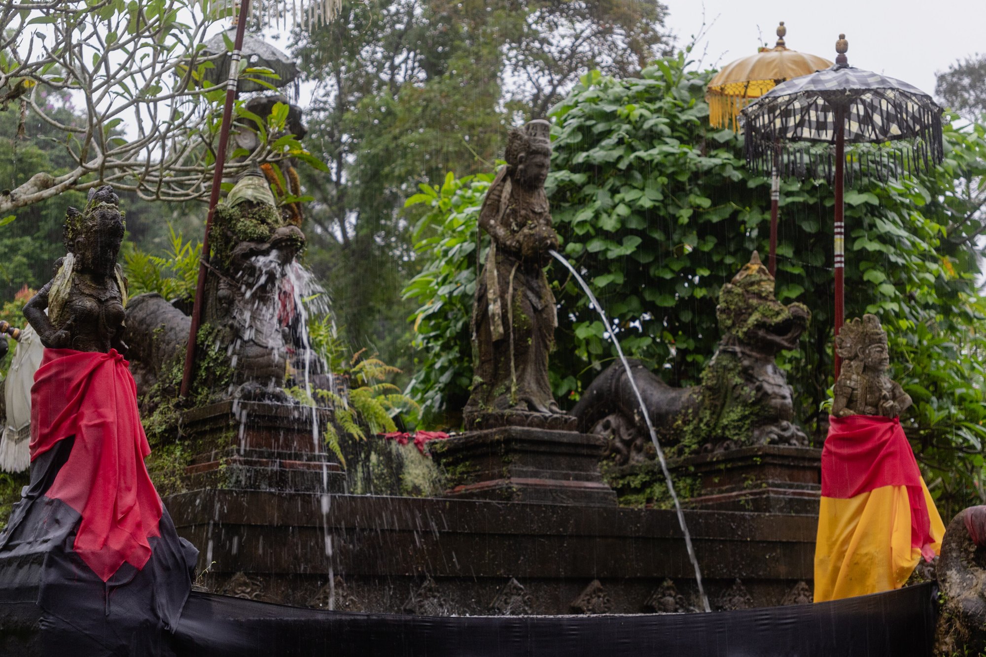 Stone deity statues pouring holy spring water at Pura Luhur Tamba Waras